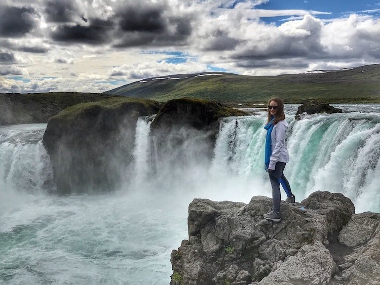 Standing on the rocks overlooking Godafoss waterfall in Iceland