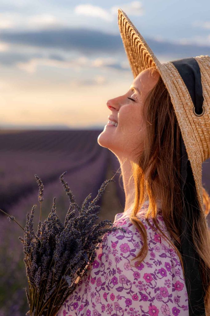 Sam wearing dress and bonnet hat walking in a lavender field.