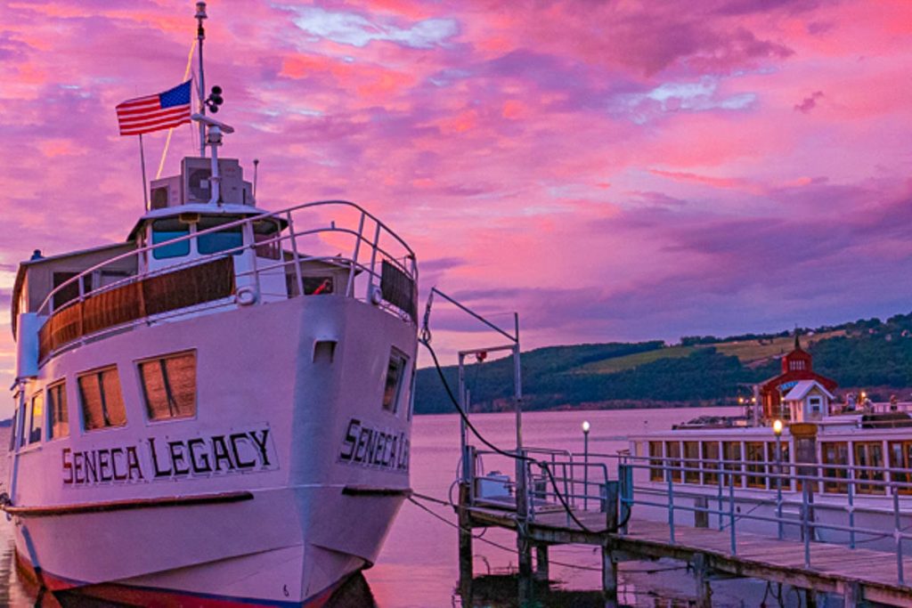 A boat docked at a marina at sunset.
