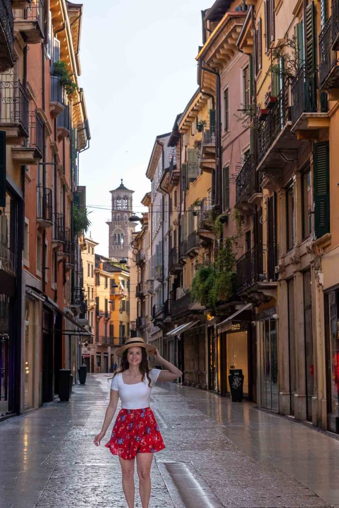 Girl in a red skirt walking down a shopping street in Italy.