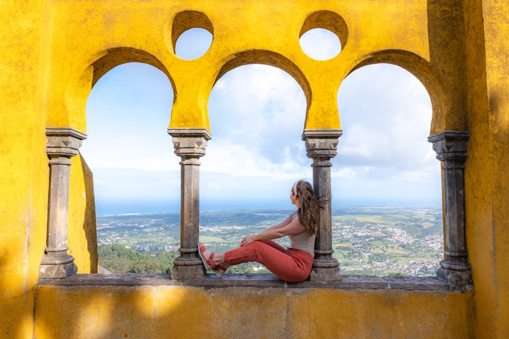 Sam sitting in a yellow archway in Sintra.