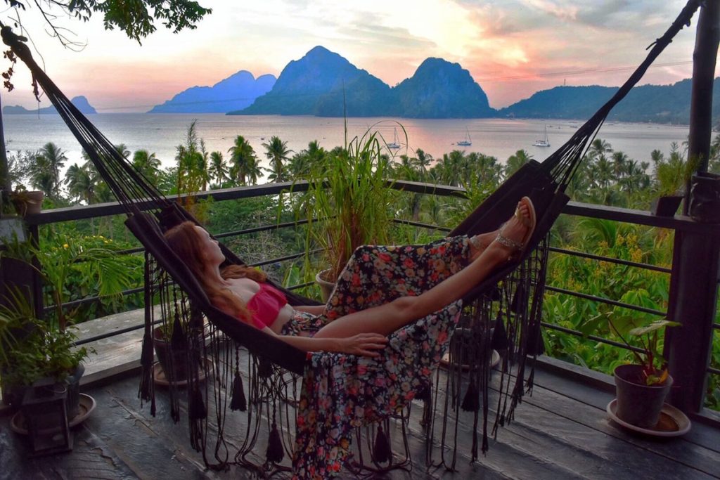 Sam lounging in a hammock overlooking a bay in the Philippines.