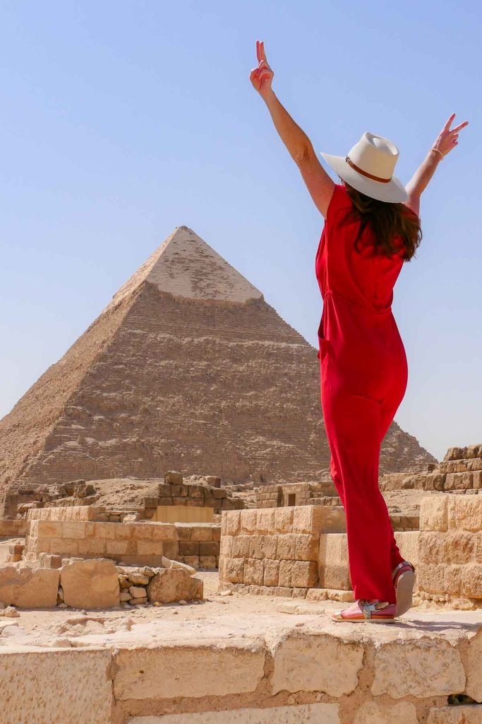 Girl standing in front of a pyramid in Egypt.
